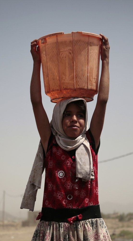 A girl carries a bucket filled with water from a well that is allegedly contaminated with cholera in Yemen.