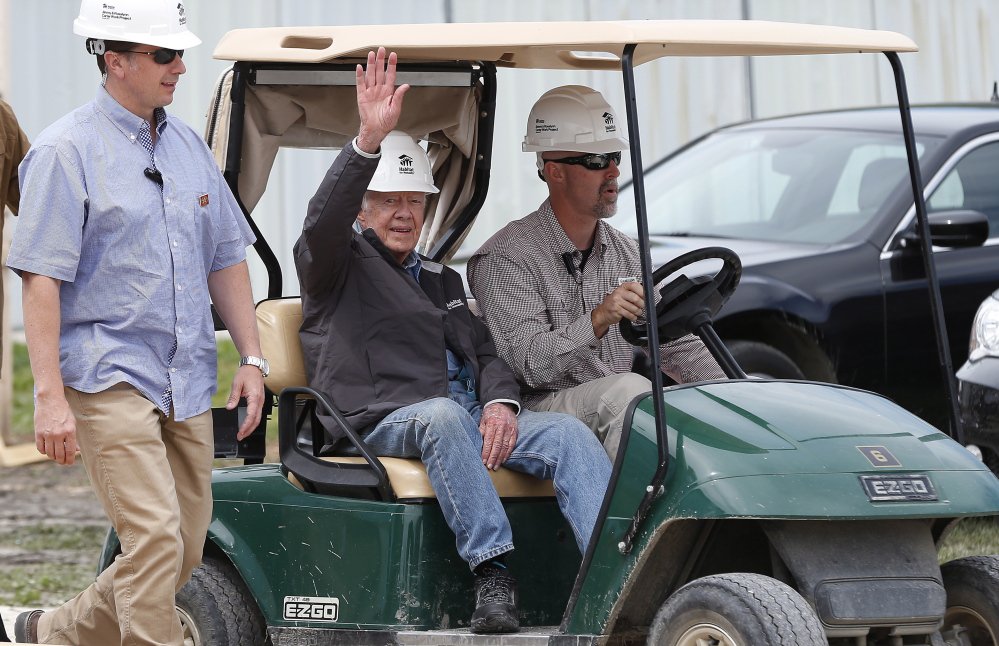Former President Jimmy Carter waves to assembled crowd members as he returns to a Habitat for Humanity site Friday.