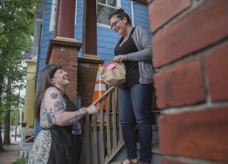 Salli Wason chats with Ann-Marie Keene after delivering ice cream to her on Sherman Street in Portland on Friday. Wason sells her homemade ice cream under the name Rosanna's Ice Cream.