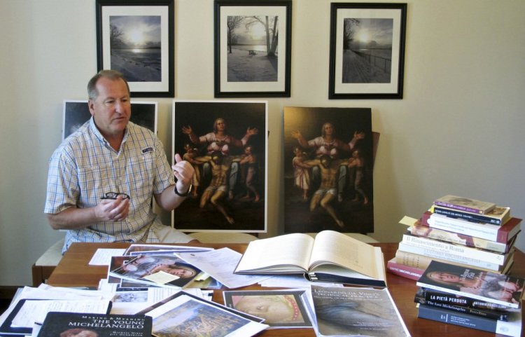 Martin Kober displays literature and copies of a family heirloom that he believes was painted by Renaissance master Michelangelo.