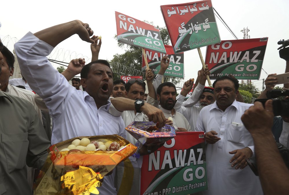 Supporters of opposition parties share sweets to celebrate the dismissal of Pakistani Prime Minister Nawaz Sharif in Peshawar on Friday.