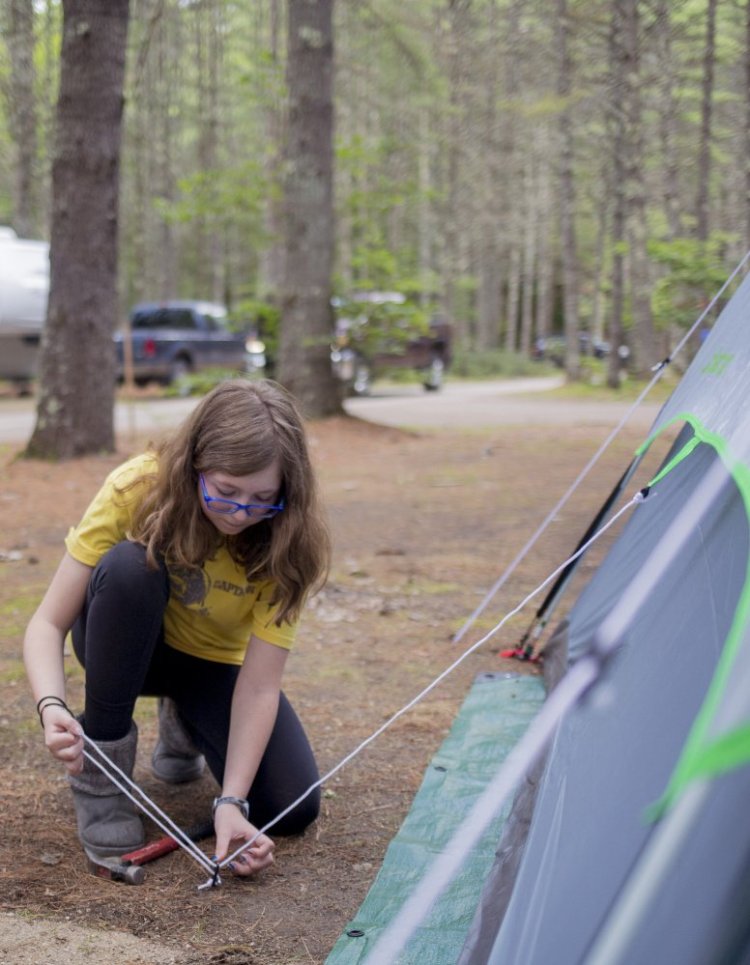 Katelyn Mitchell helps set up the tent with her dad, Steve Mitchell,  at Sebago Lake State Park. The pair came up from their home in Rhode Island for a few days of camping.