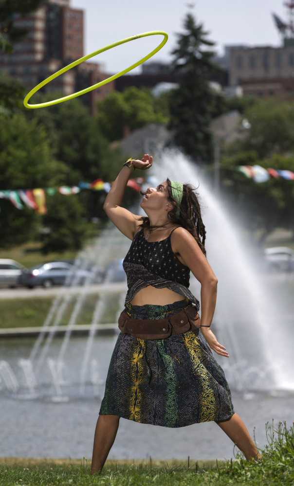 Hoop dancer Grace Raggiani grooves to loud salsa music during the 15th annual Festival of Nations. Raggiani said she dances at the park almost every day, but the music from the festival was a welcome addition to her routine. Staff photo by Ben McCanna