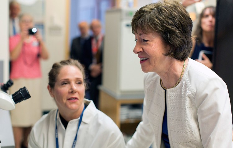 U.S. Sen. Susan Collins, R-Maine, talks with Sarah McCarthy, left, a pre-doctoral fellow at the Maine Medical Research Center in Scarborough, while McCarthy analyzes sections of kidney tissue from a mouse on Friday. 