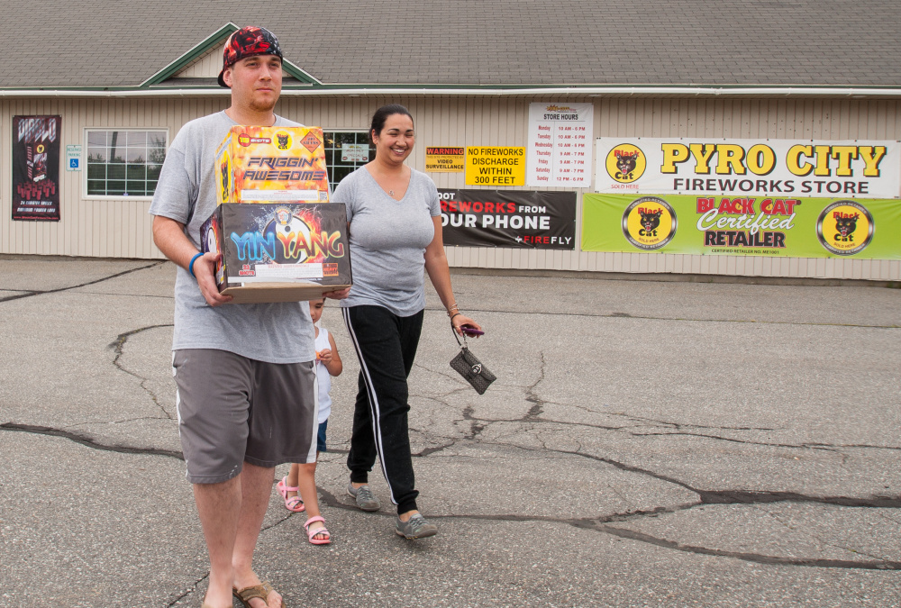 Stocking up on fireworks for July Fourth are Leland, left, and April Kelley, of Dedham, Mass., with their 3-year-old daughter Lea. They are visiting family in Maine and stopped at Pyro City Fireworks in Manchester on Saturday.