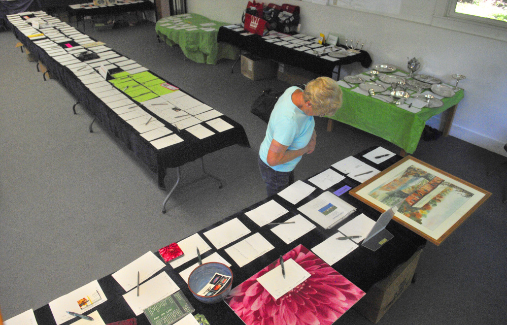 A parishioner takes a peek at items up for silent auction on July 6, 2016, at the Wayne Community Church in Wayne. The auction is a fundraiser for the church and will be held this year from Thursday through Saturday.