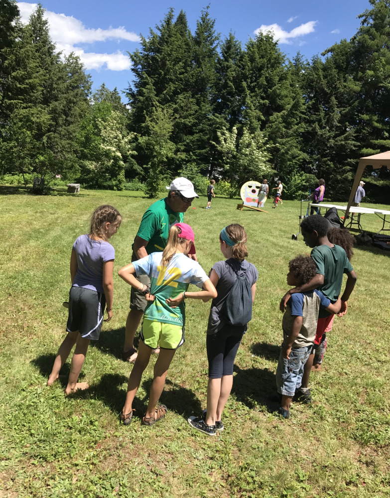 Peter Walsh, center, explains the rules of the upcoming foot race to the children he rounded up to take part at Dresden's SummerFest on Sunday at the Pownalborough Court House.