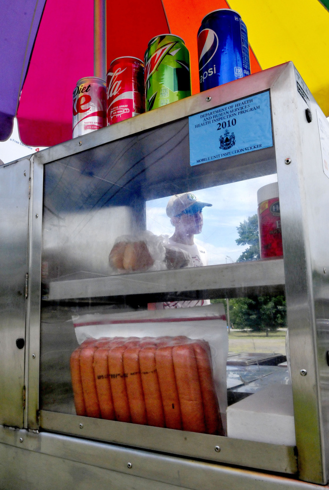 Staff photo by David Leaming
Dana Purington, owner of Dana's Dogz food stand, is seen through the steamed windows of his mobile hot dog stand parked off Maine Avenue in Farmingdale on Monday.