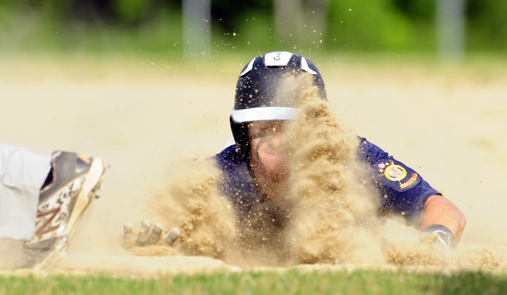 Augusta baserunner Dylan Brown slides safely into first base to avoid being picked off during an American Legion Zone 2 game against Gardiner on Tuesday at Hoch Field in Gardiner.