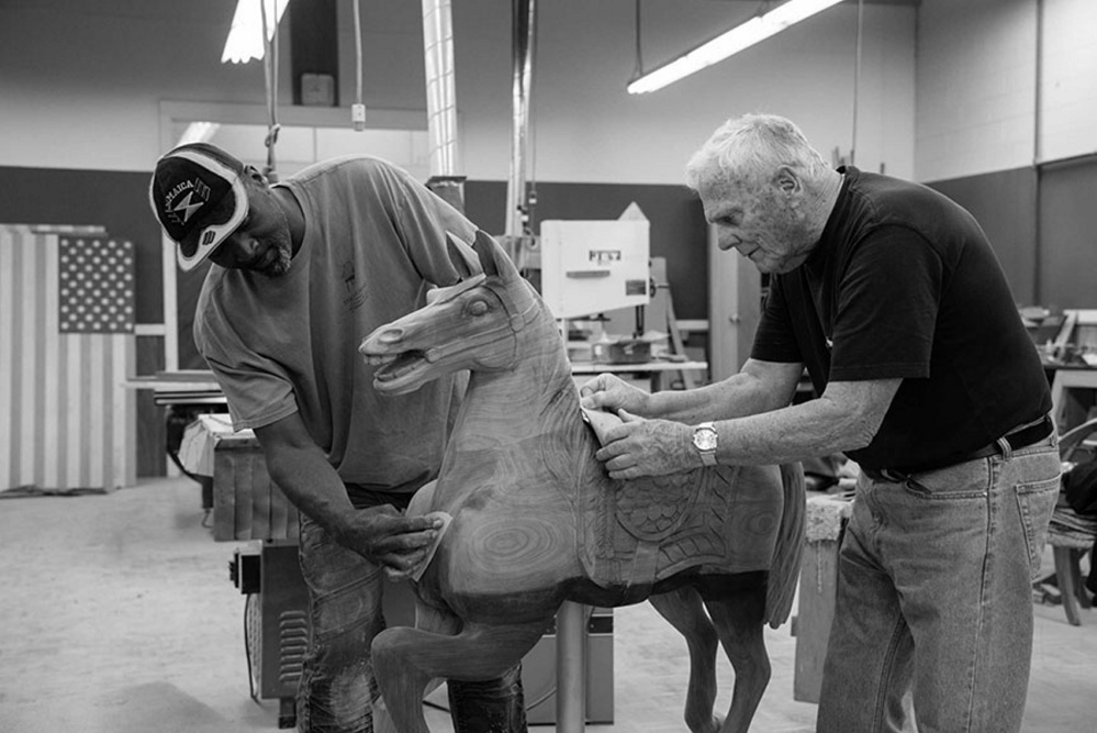 Ramsy Uter and Tom Moser work on their carving of a small carousel horse that will be making its debut at the Maine State Museum's upcoming exhibition, "Thos. Moser: Legacy in Wood," on view for six months beginning July 15.