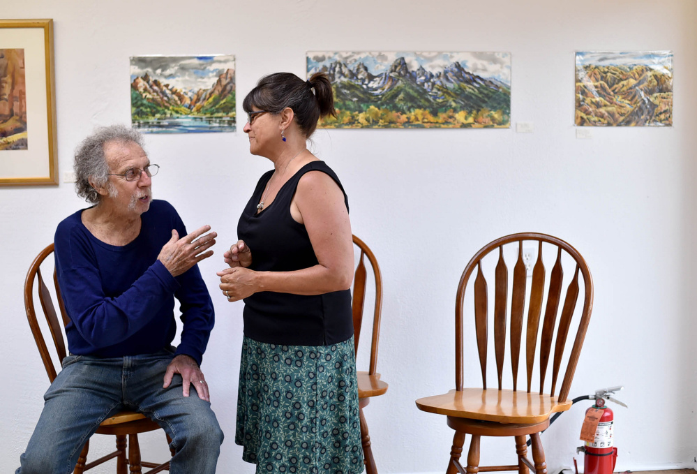Christy Whitmore, center, greets Stu Silverstein, of Solon, at a Wednesday gathering of artists at Skowhegan's newest art venue, Fourteen Madison, to plan Wesserunsett Arts Council's annual Open Studio Tour, which will be held Aug. 12 this year, and not in October as in previous years.