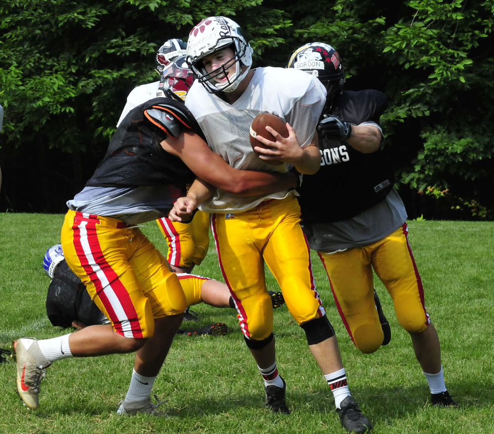 Staff photo by David Leaming
East team quarterback Garrett McSweeney gets sacked during practice for the Lobster Bowl on Tuesday at Dover-Foxcroft.