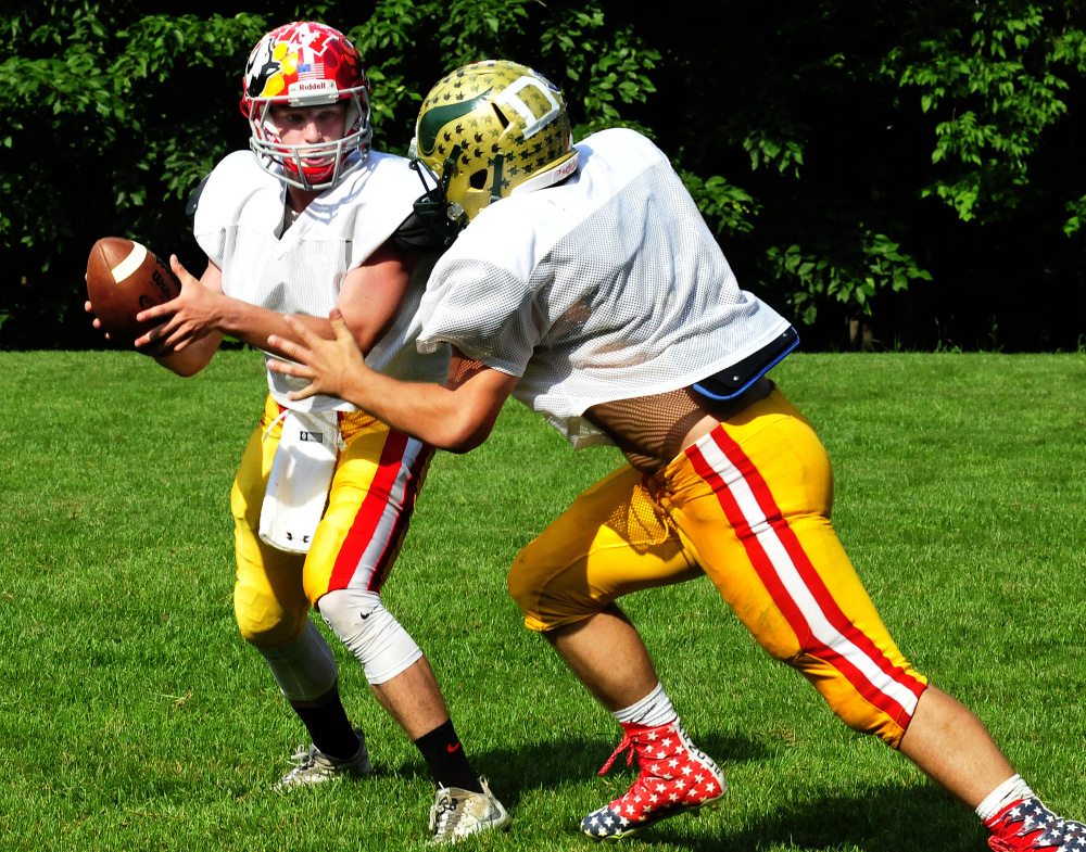 Staff photo by David Leaming
East team quarterback Taylor Heath hands off to a teammate during practice for the Lobster Bowl on Tuesday at Dover-Foxcroft.