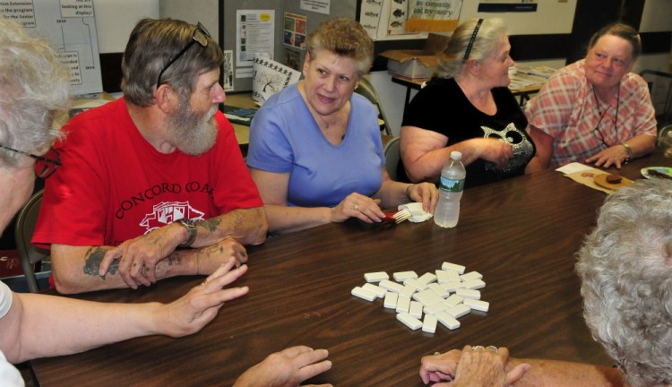 Paula Knox, second from left, asks a question while learning to play dominoes along with Victor LeCourt, Agnes Totherow and Debra LeCourt at the Senior Gathering in Skowhegan on Wednesday.