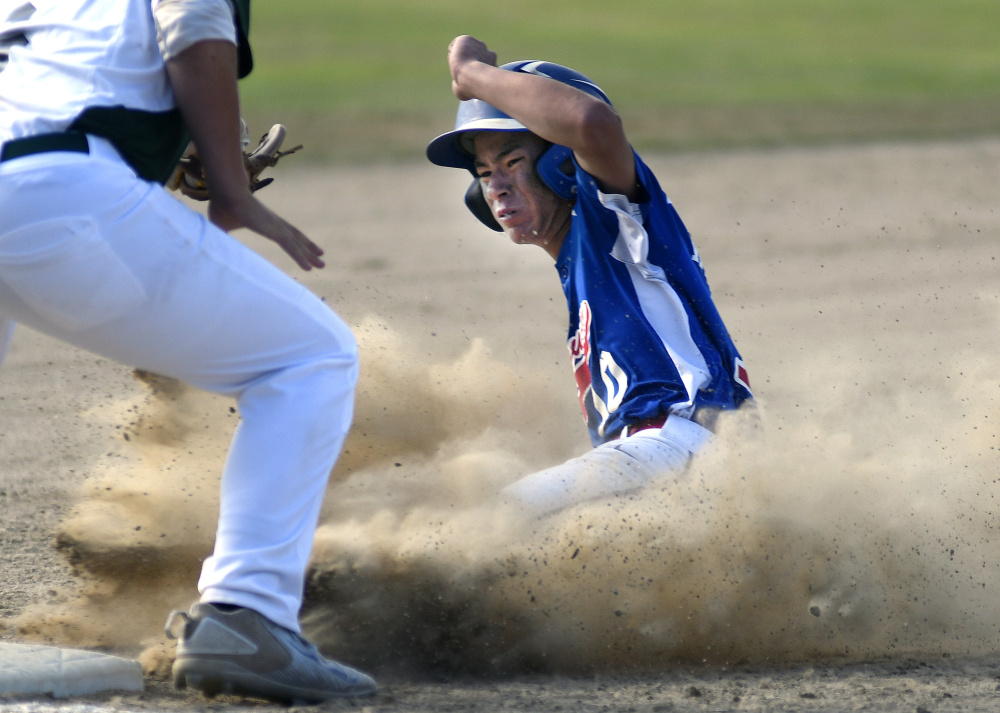 Augusta's Akira Warren slides under the throw to Tri-County's Duncan Jones during the Babe Ruth 14U state championship game against Tri-County on Monday in Augusta.