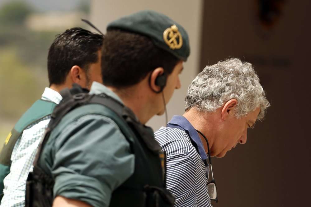 Gormer President of the Spanish Football Federation Angel Maria Villar, right, is led by Spanish Civil Guard policeman to enter Federation headquarters during an anti-corruption operation in Las Rozas, outside Madrid on Tuesday.