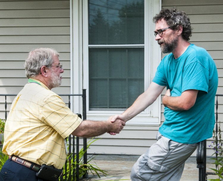 Winthrop School Superintendent Gary Rosenthal chats with parent David Hughes on Thursday at Hughes' home, on the corner of Main and Royal streets in Winthrop. Hughes put up a large sign on his lawn urging fellow residents to reject the school budget Tuesday, saying it is too low.
