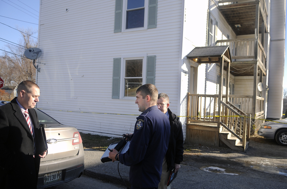 State police detectives confer Nov. 24, 2015, outside an apartment building on Washington Street in Augusta, where a homicide occurred.