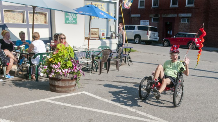 Maggie Warren, 71, of Hallowell, pedals her recumbent bicycle Friday at Slate's Bakery in downtown Hallowell. The outdoor tables are an early morning gathering place.