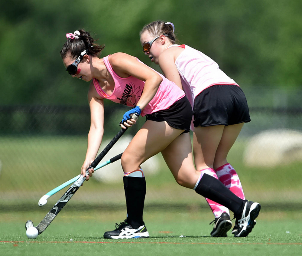 Staff photo by Michael G. Seamans 
 Skowhegan's Maliea Kelso (2) battles for the ball with a player from Spruce Mountain during the 7th annual Battle for Breast Cancer field hockey tournament Saturday at Thomas College in Waterville.