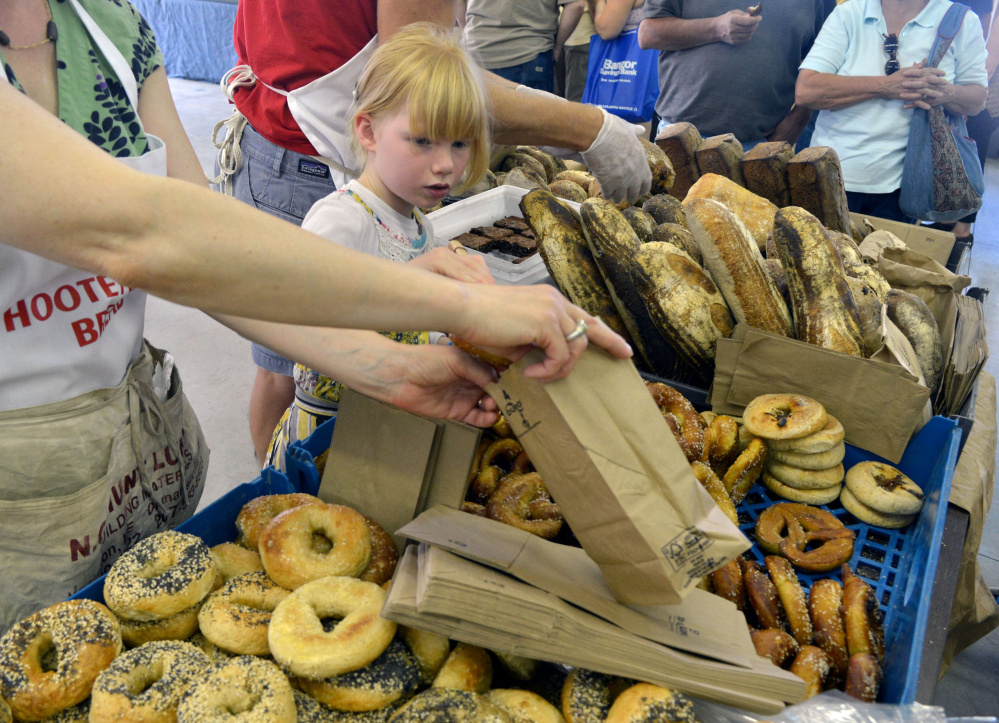 Francis DeGeer (cq), helps her mother, Marcia and father, Derek, fill orders of bread from their bakery table Hootenanny Bread at the Maine Artisan Bread Fair at the Skowhegan Fair Grounds on Saturday, July 30, 2016.