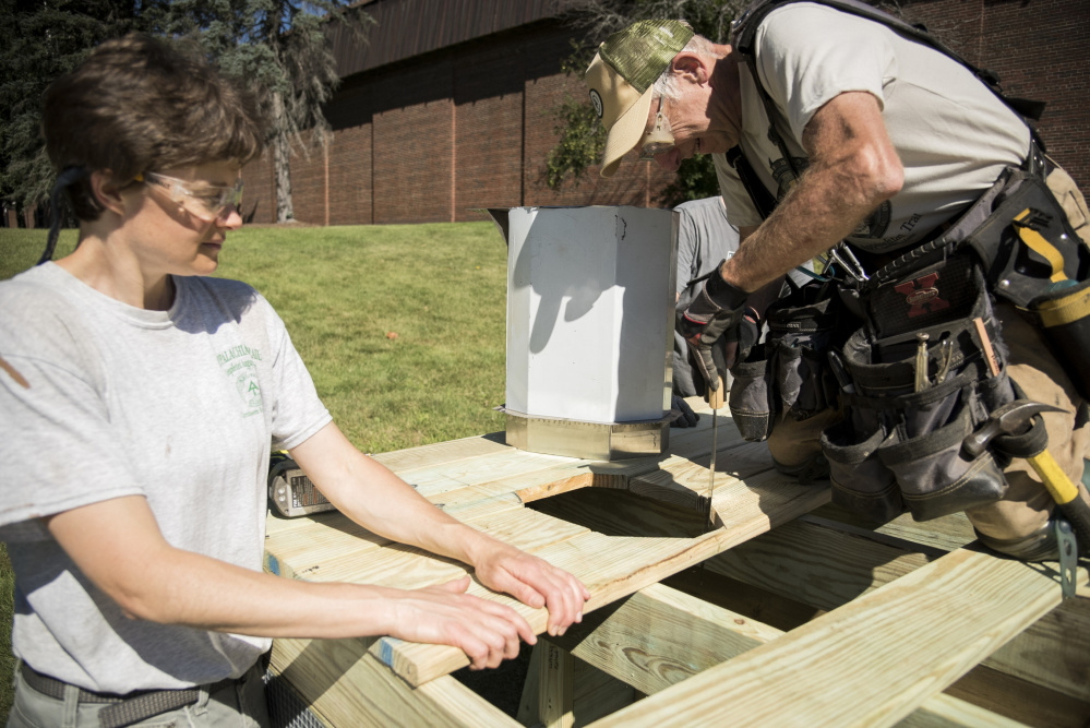 Laura Flight, left, of Readfield, and Dana Humphrey, of Palmyra, construct a privy built as a demonstration project for the Appalachian Trail Conservancy Conference held at Colby College in Waterville.