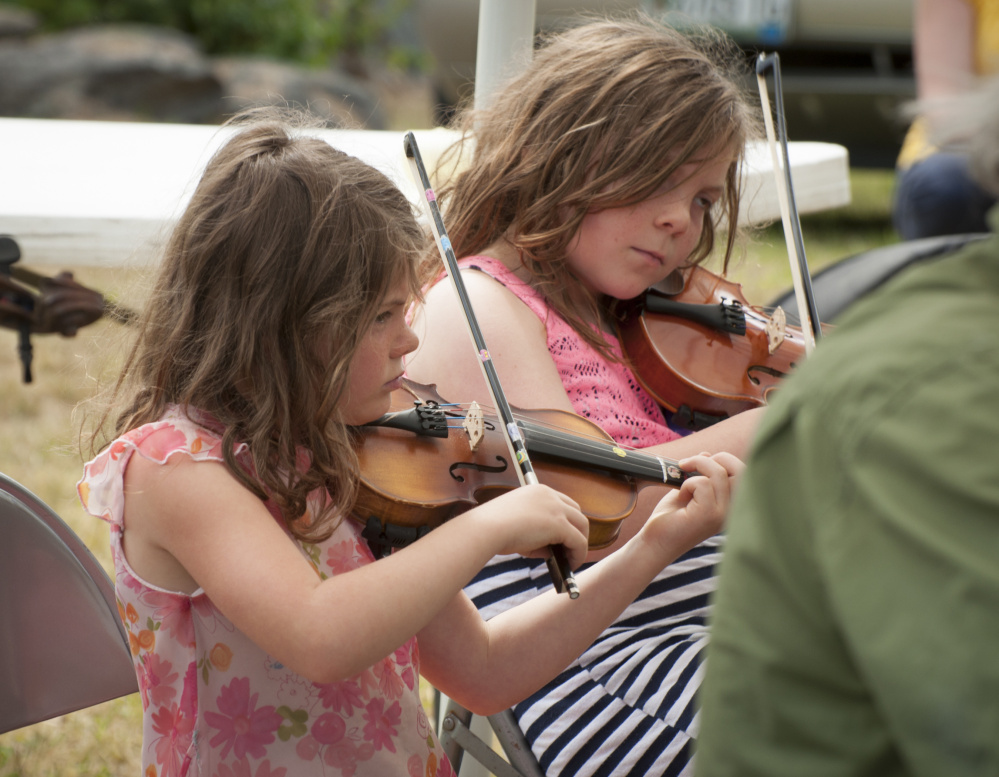 Mary Philbrick, 6, and her sister Allison, 8, of Alna, play their fiddles while jamming with other musicians at the East Benton Fiddle Convention and Contest at Littlefield Farm on Richard's Road.