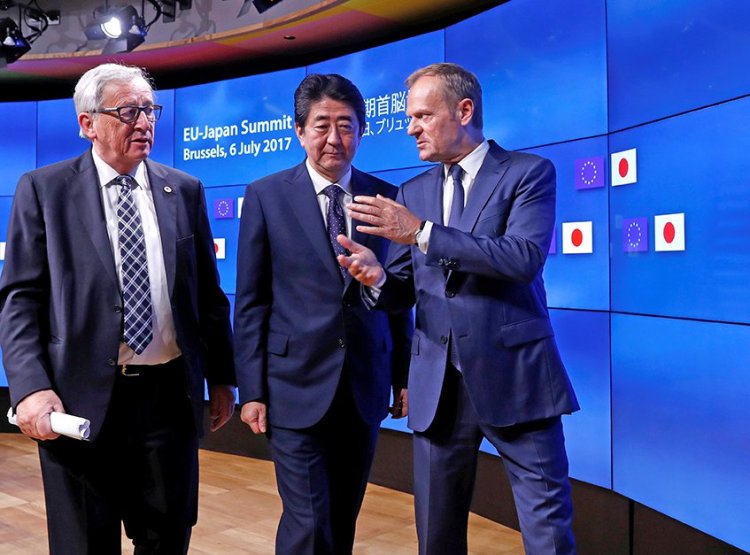 Japan's Prime Minister Shinzo Abe talks with European Commission President Jean-Claude Juncker, left, and European Council President Donald Tusk at the end of a EU-Japan summit in Brussels on Thursday.  