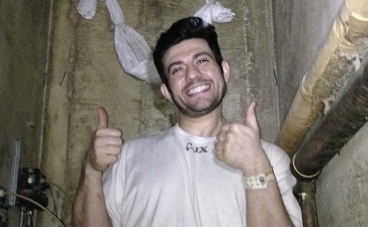 Adam Hossein Nayeri, an escapee of the Orange County Jail, gives a thumbs-up after crawling through a hole cut in a metal screen to reach plumbing shafts within the jail walls at the prison in Santa Ana, Calif. The image is from a cellphone video released by Nayeri's attorney.