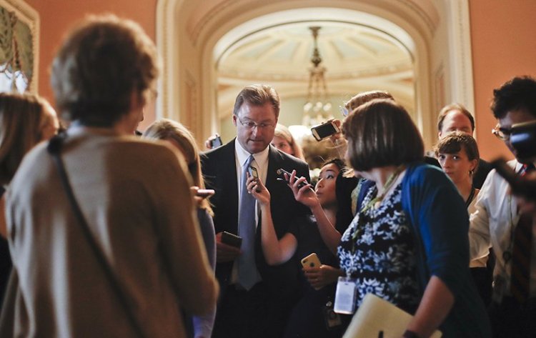 Sen. Dean Heller, R-Nev.,  surrounded by members of the media on Capitol Hill on July 13.