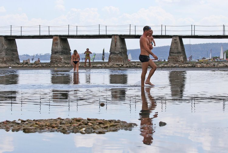 People walk in a shallow area that has emerged in Lake Bracciano north of Rome during the drought. Meteorologists say Italy experienced one of its driest springs in 60 years and that some parts of the country have seen rainfall totals 80 percent below normal. 