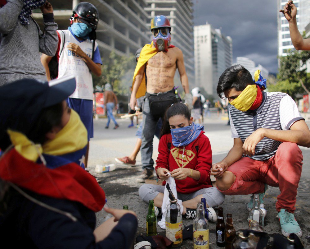 Demonstrators prepare homemade bombs to be used against police during a protest against the installation of a constitutional assembly Friday in Caracas, Venezuela.