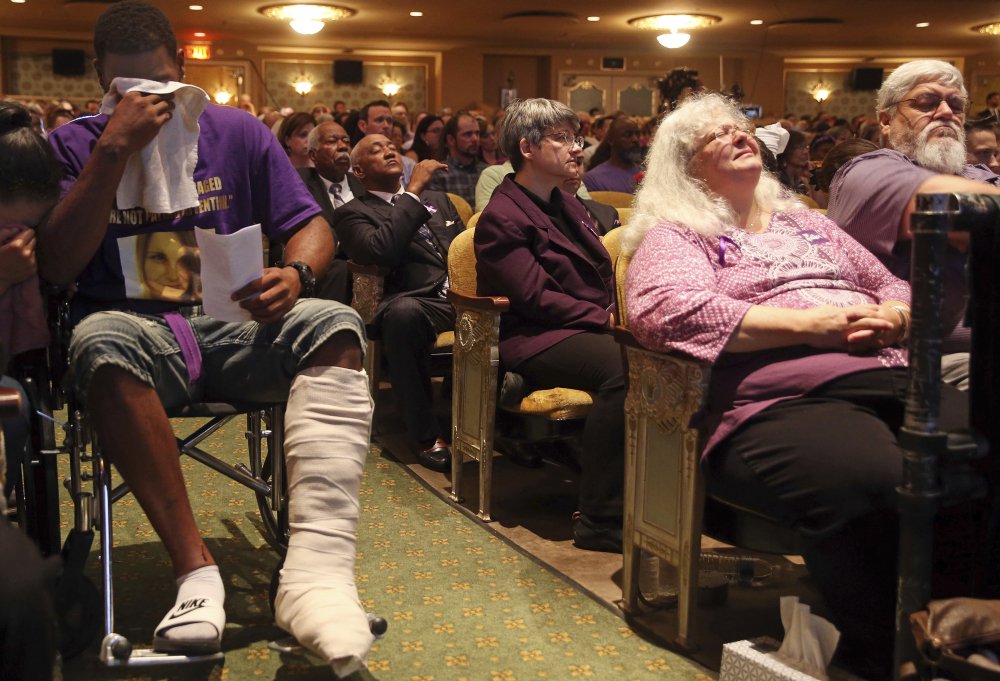 From left, Marcus Martin and Susan Bro, Heather Heyer's mother, listen during a memorial for Heyer on Wednesday at the Paramount Theater in Charlottesville, Va. Heyer was killed Saturday, when a car rammed into a crowd of people protesting a white nationalist rally. Martin pushed his fiancee out of the way of the vehicle that killed Heyer.