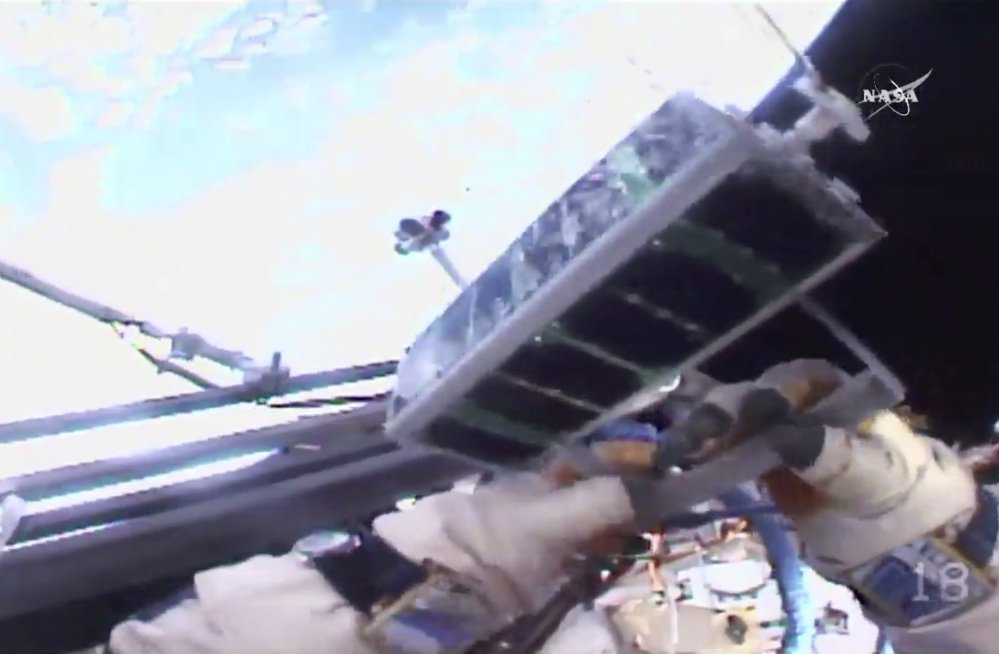 In this image made from video provided by NASA, Russian cosmonaut Sergey Ryazanskiy holds a mini satellite before launching it by hand from the International Space Station on Thursday.