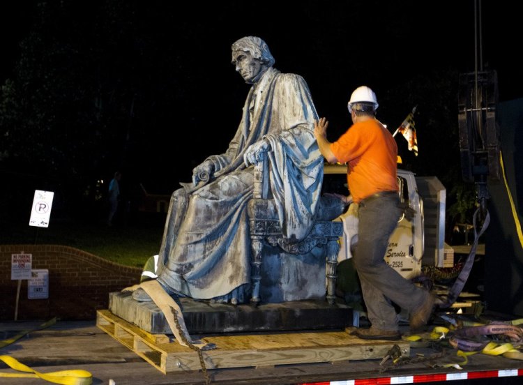 Workers sits the monument dedicated to U.S. Supreme Court Chief Justice Roger Brooke Taney on a flatbed truck after it was removed from outside the Maryland State House, in Annapolis, Md., early Friday, Aug. 18, 2017. Maryland workers hauled several monuments away, days after a white nationalist rally in Charlottesville, Virginia, turned deadly.