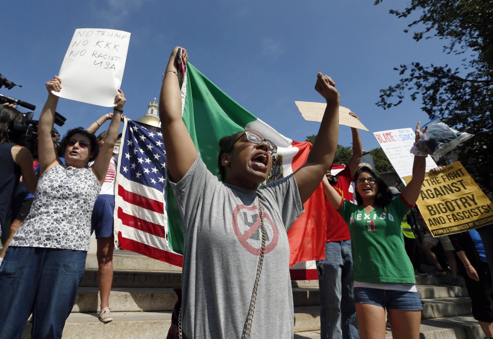 Counterprotesters hold signs and chant at the Statehouse before a planned "Free Speech" rally by conservative organizers begin on the adjacent Boston Common, Saturday, Aug. 19, 2017, in Boston.  Police Commissioner William Evans said Friday that 500 officers, some in uniform, others undercover, would be deployed to keep the two groups apart.  (AP Photo/Michael Dwyer)