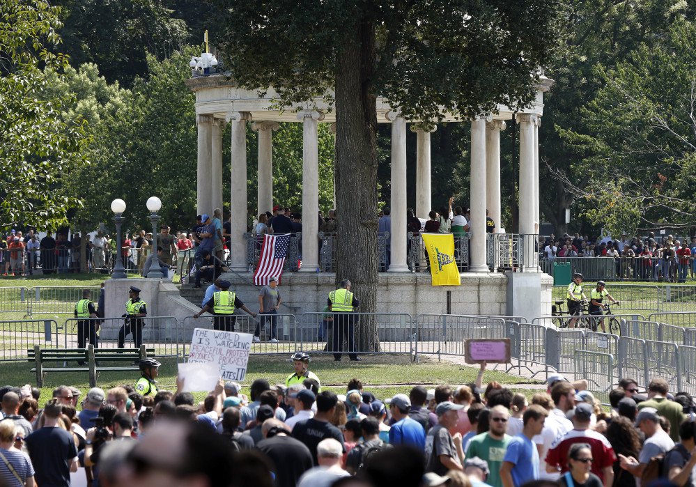 Organizers gather on a bandstand on Boston Common during a "free speech" rally staged by conservative activists Saturday. Counterprotesters line barricades ringing the bandstand.