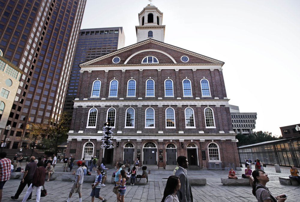 Pedestrians pass Faneuil Hall in Boston Monday. As U.S. cities grapple with what to do with Confederate monuments, some are suggesting renaming the historic hall,  given to the city by a wealthy merchant who traded slaves.