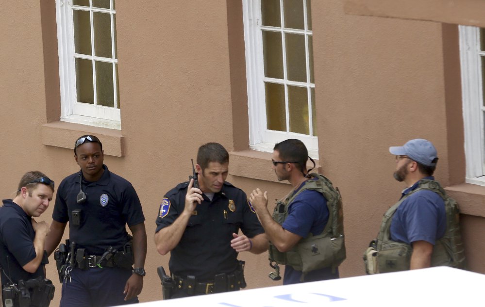 Police gather near the scene of a shooting in Charleston, S.C., on Thursday. Authorities say a disgruntled employee shot one person and was holding hostages in a restaurant in an area that is popular with tourists.