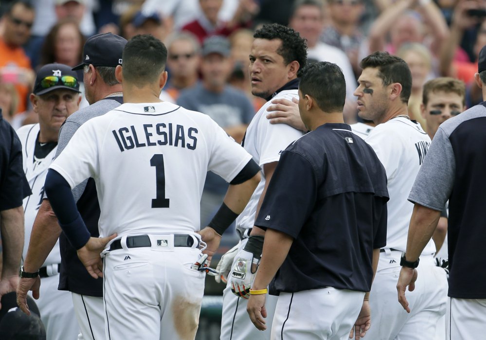 The Tigers' Miguel Cabrera looks back at the New York Yankees as he is guided off the field by teammate Ian Kinsler, right, and Jose Iglesias after a bench-clearing fight in the sixth inning of Thursday's game in Detroit.