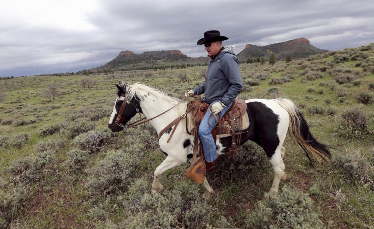 Interior Secretary Ryan Zinke rides a horse in the new Bears Ears National Monument near Blanding, Utah, in May. Zinke said Thursday that he won't seek to rescind any national monuments carved from wilderness and ocean by past presidents, but would press to change some boundaries and left open the possibility the Trump administration could allow new access to oil and gas drilling, logging and other industries.