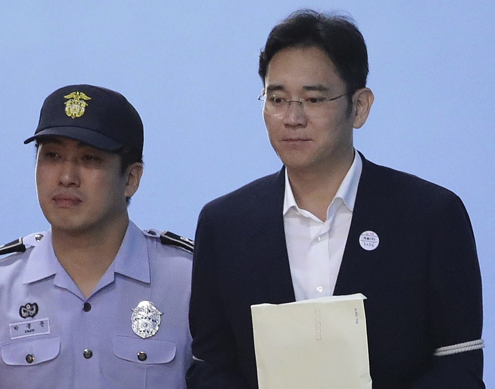 Samsung Electronics Co. Vice Chairman Lee Jae-yong, right, is escorted from Seoul Central District Court on Friday.
