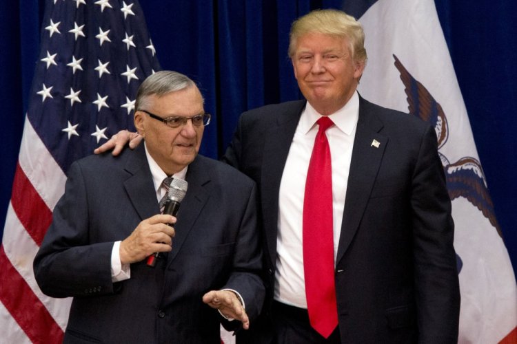 President Trump is joined onstage by Joe Arpaio at a campaign event in Marshalltown, Iowa. Trump pardoned the former sheriff after his conviction for intentionally disobeying a judge's order in an immigration case.