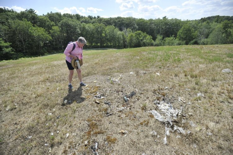 Kim Rich looks at what she thinks may be trash protruding from the closed landfill, which at one time was capped with 2 feet of material. Rich and other residents have pressured the city to deal with issues at the site.