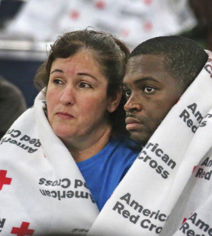 Displaced South Houston residents Oralia Guerra and Diamond Robinson huddle together to stay warm underneath Red Cross blankets at the George Brown Convention Center in Houston on Monday, Aug. 28, 2017, in the wake of Tropical Storm Harvey. Floodwaters reached the rooflines of single-story homes Monday and people could be heard pleading for help from inside as Harvey poured rain on the Houston area for a fourth consecutive day after a chaotic weekend of rising water and rescues.