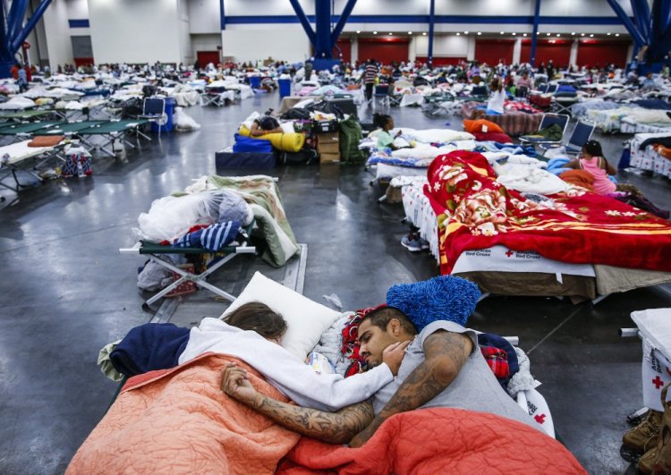 Tammy Dominguez and her husband, Christopher, sleep on cots at the George R. Brown Convention Center in Houston, where 10,000 people were taking shelter Wednesday.