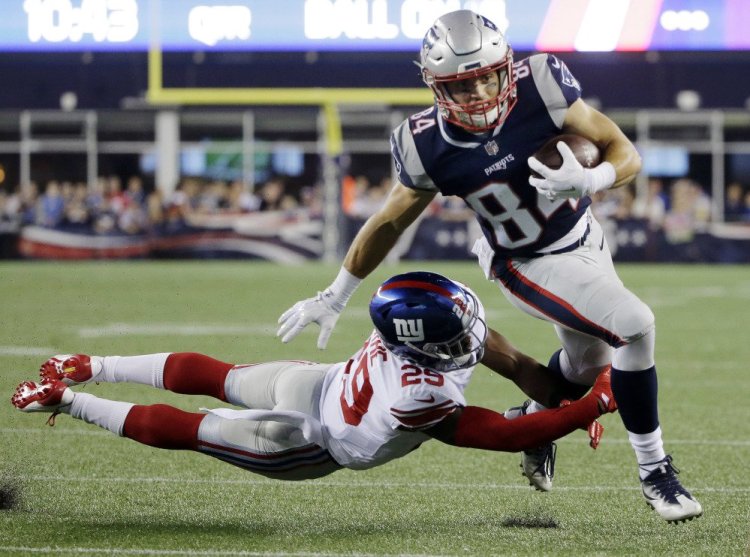 Patriots wide receiver Austin Carr slips an attempted tackle by Giants safety Nat Berhe on his way to a first-half touchdown Thursday night in Foxborough, Mass.