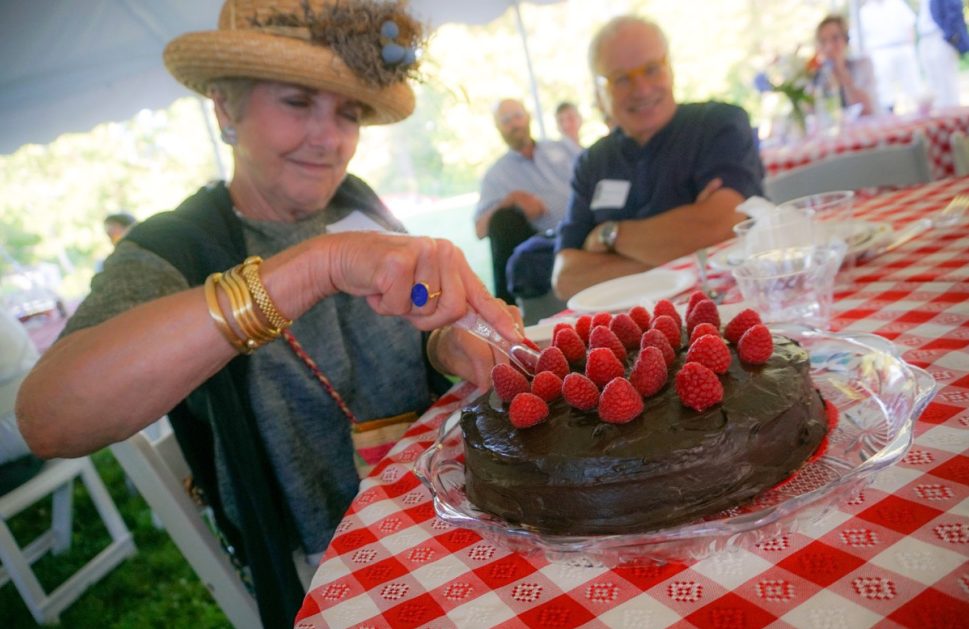 Luana Frois, of Westport Island, slices into a chocolate whiskey cake for which she and her husband were high bidders at Lincoln County Historical Association's Kermess at Pownalborough Court House.