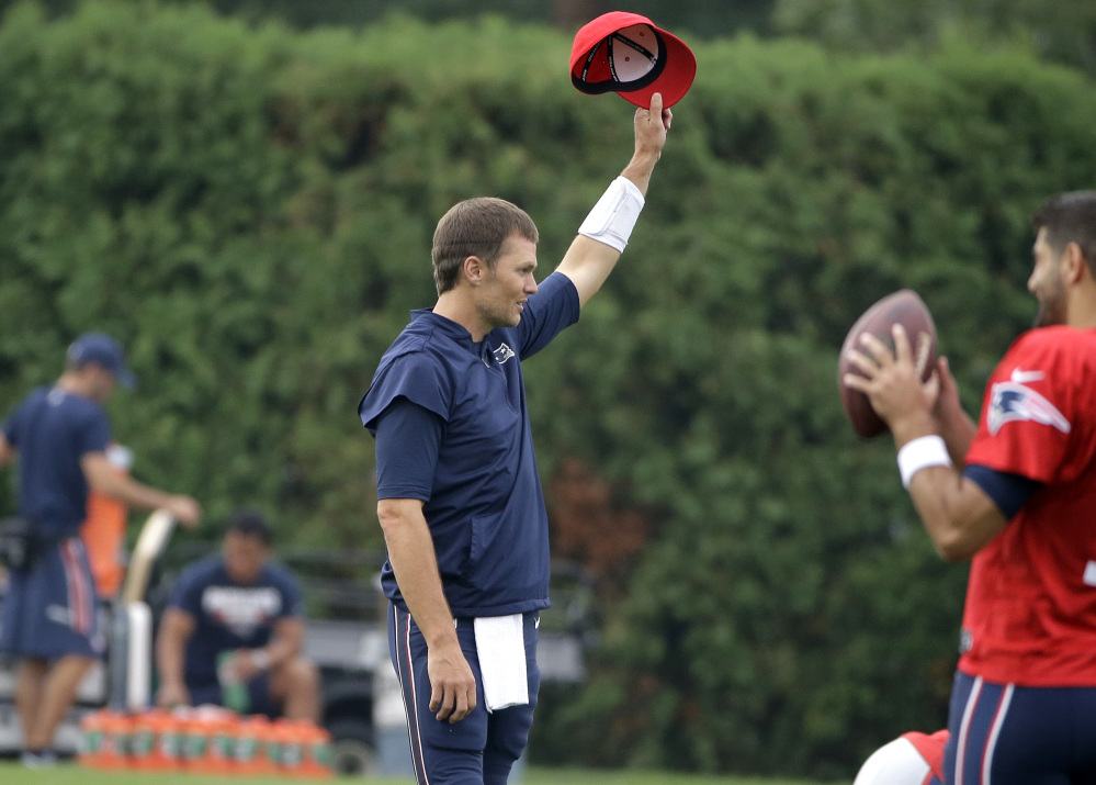 New England Patriots quarterback Tom Brady removes his hat as a crowd of spectators sings "Happy Birthday" to him at training camp Thursday in Foxborough, Massachusetts.
