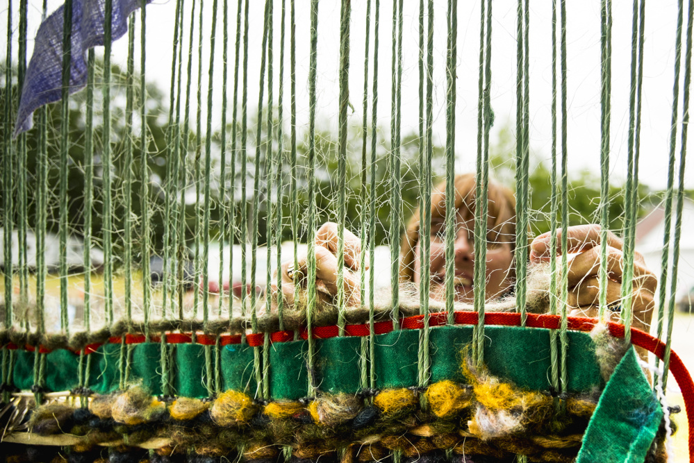June Jordan of Randolph, Massachusetts, participates in the community loom Saturday at the Monmouth Fair. Weavers were allowed to bring their own materials or use fabric provided there.
